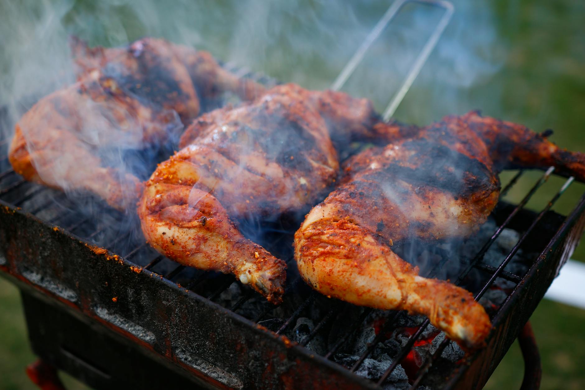 Grilled chicken on a charcoal grill with smoke